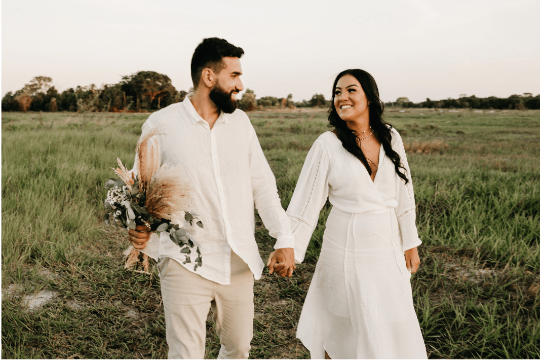 bride and groom walking in the field 