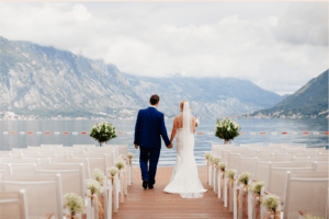 bride and groom improving their relationship with money dates to build wealth beyond the wedding as they look out onto the water