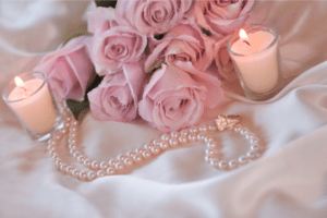 pink flowers, candles, and pearls