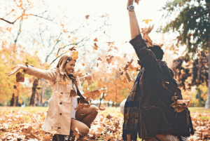 couple playing in the leaves