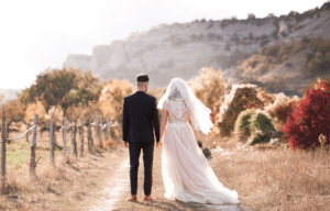 fall wedding couple walking on trail 